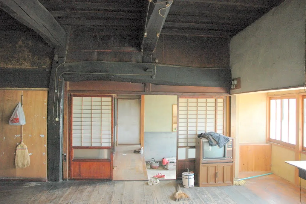 Old interior room in the Hakuba kominka before renovation with exposed dark timber beams