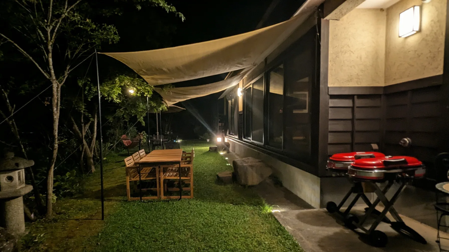 Garden dining and barbecue area illuminated at night
