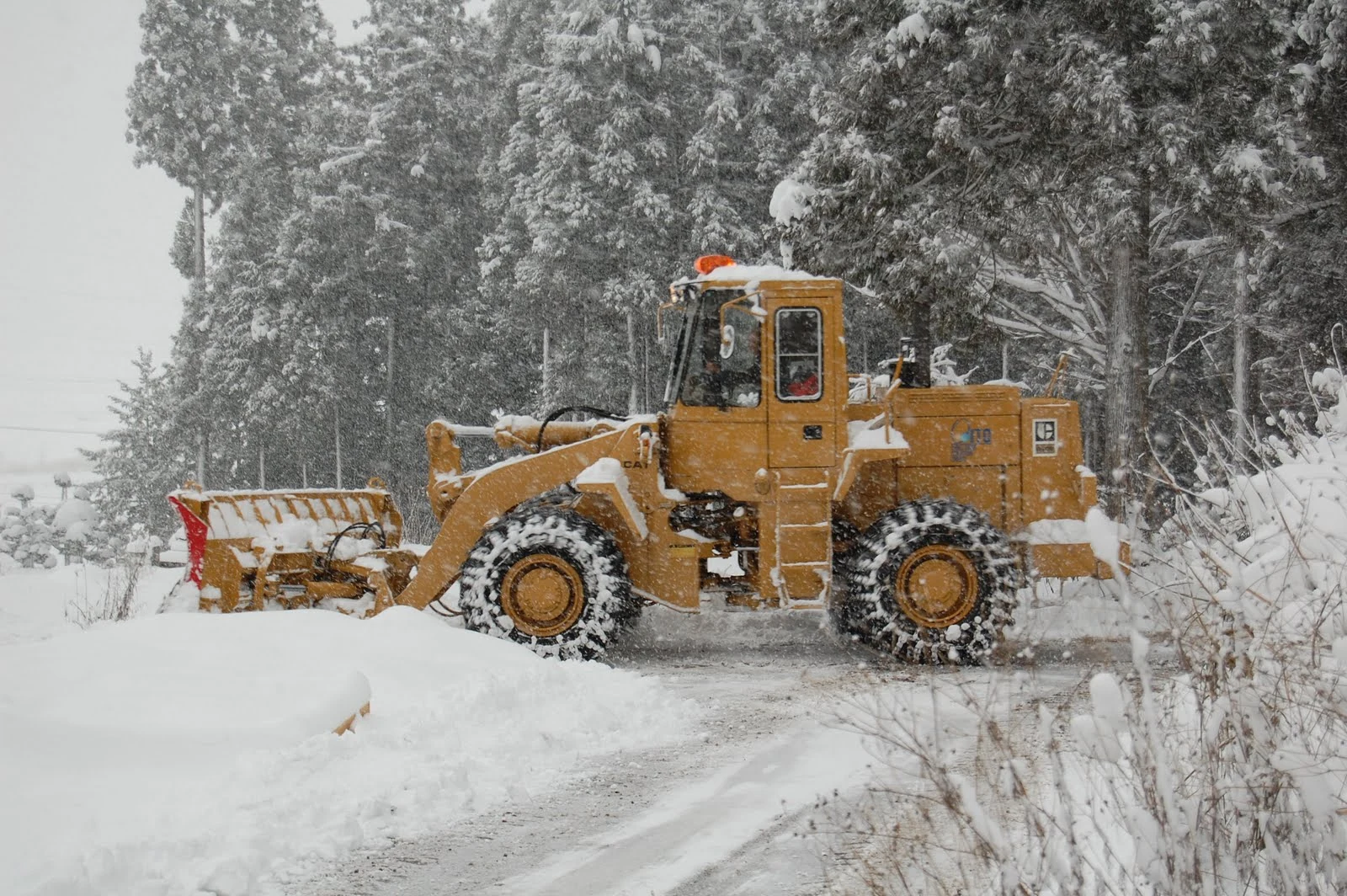 Snowplough clearing deep winter snow beside Rental Farmhouse Tamaki in Hakuba